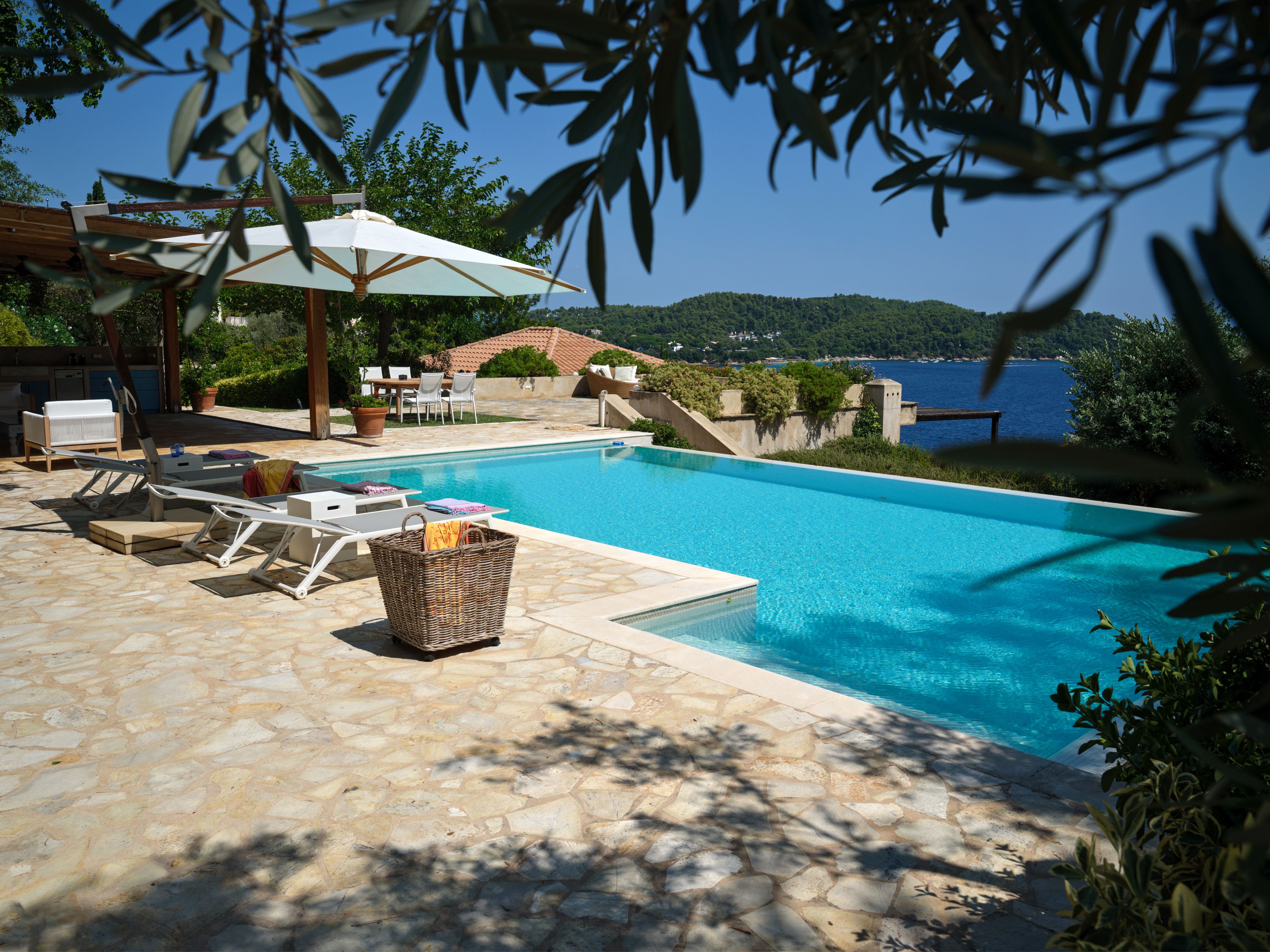Sunbeds on the pool terrace with the sea beyond