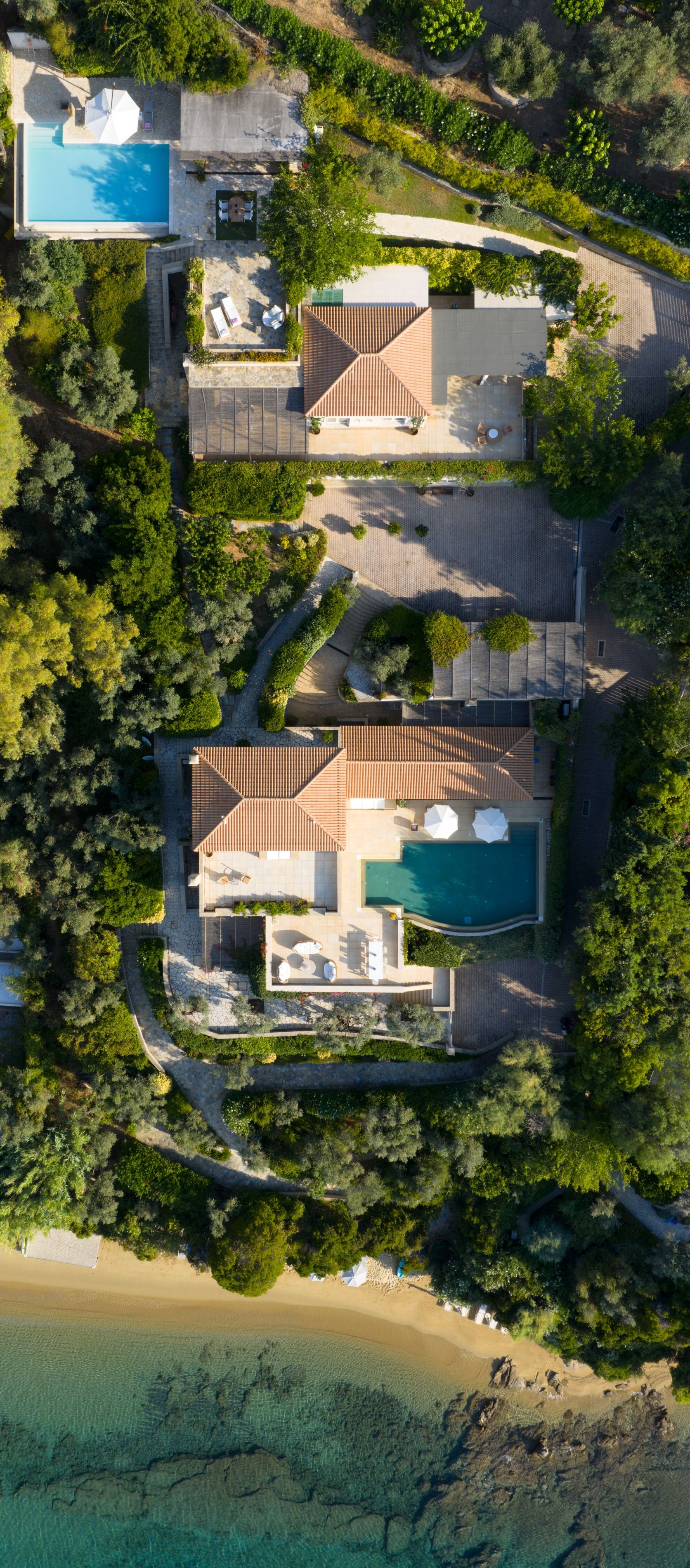 Overhead drone view of the estate, both pools and the beach