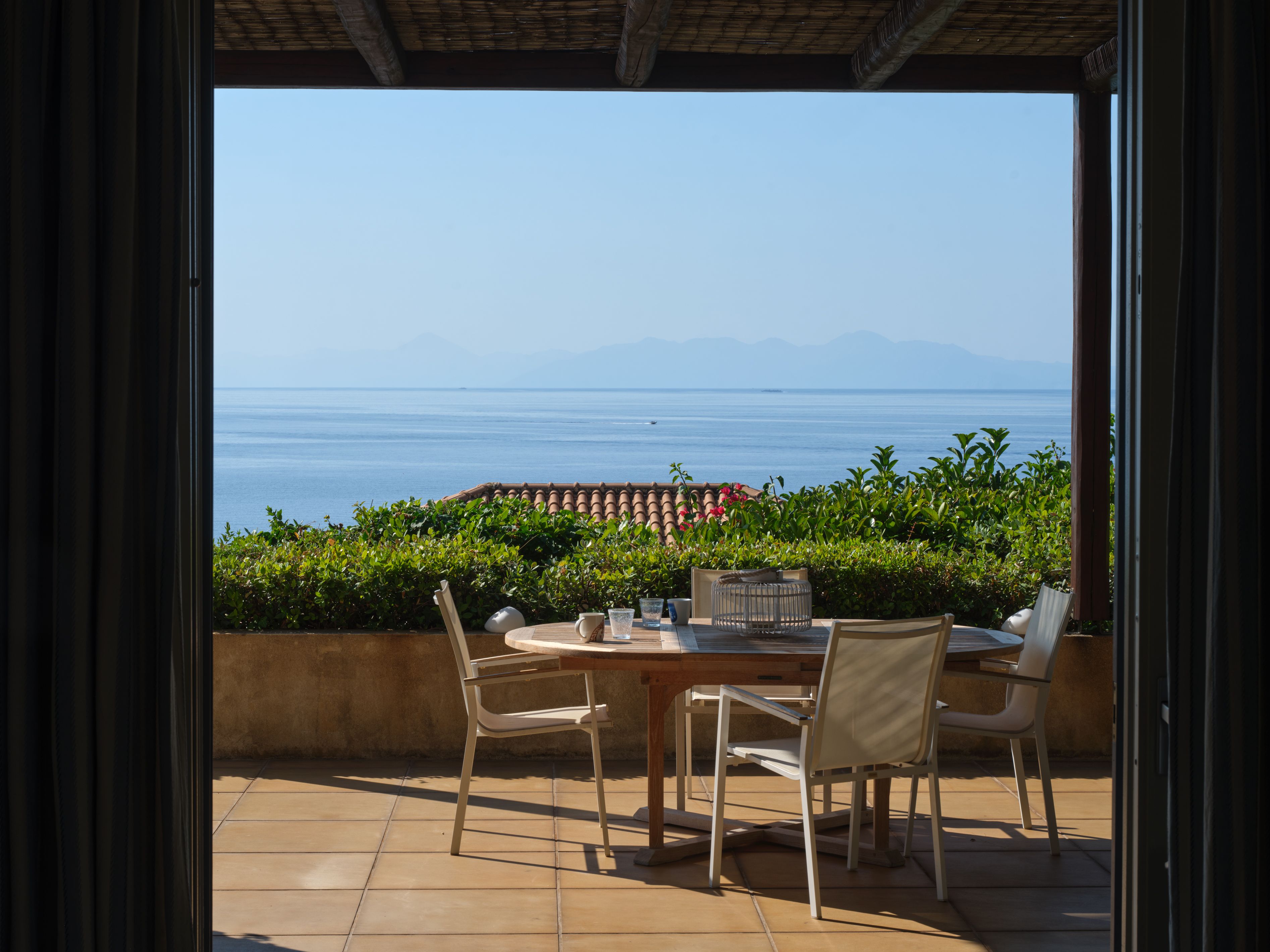 The table on the covered terrace outside a first-floor suite, with the sea view